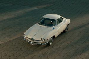Restored white Alfa Romeo Giulia 1600 Sprint Speciale parked in Berlin, showcasing its sleek, aerodynamic design and hand-crafted bodywork